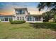 A sunroom with bright, natural light looks out over the manicured lawn at 2490 Kensington Greens Dr # 0, Sun City Center, FL 33573