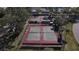 Aerial view of well-maintained tennis courts surrounded by lush greenery, perfect for recreational play and exercise at 2490 Kensington Greens Dr # 0, Sun City Center, FL 33573
