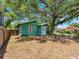 A green home with a fenced backyard and some shade trees at 302 W Curtis St, Tampa, FL 33603
