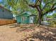 Charming backyard with a mature tree providing ample shade and a cozy green cottage-style home at 302 W Curtis St, Tampa, FL 33603