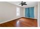 Cozy bedroom featuring beautiful hardwood floors, neutral paint, and a window with calming blue curtains at 302 W Curtis St, Tampa, FL 33603