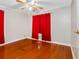 Cozy bedroom with hardwood floors, fan, and bright red curtains, ready for relaxation at 302 W Curtis St, Tampa, FL 33603