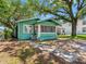 Charming cottage-style home with a screened-in porch and mature trees in a residential neighborhood at 302 W Curtis St, Tampa, FL 33603
