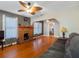 Cozy living room with a brick fireplace, ceiling fan, hardwood floors, and neutral paint at 302 W Curtis St, Tampa, FL 33603