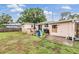 Backyard featuring a patio area with outdoor seating, a grill, and a lush green lawn at 3035 Hillview St, Sarasota, FL 34239