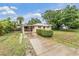 Charming single-story home featuring a concrete driveway, lush lawn, and mature trees at 3035 Hillview St, Sarasota, FL 34239