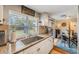 Bright kitchen with granite countertops, stainless sink, white cabinets, and large window overlooking the backyard at 3035 Hillview St, Sarasota, FL 34239