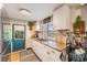 Cozy kitchen features granite counters, white cabinets, and a door to the outside at 3035 Hillview St, Sarasota, FL 34239