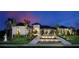 Luxury home showcasing manicured lawn, elegant water feature, and lush landscaping under the dusk sky at 316 Vistera Blvd, Nokomis, FL 34275