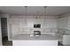 Bright, modern kitchen featuring white cabinetry, stainless steel appliances, and a large center island with pendant lighting at 316 Vistera Blvd, Nokomis, FL 34275