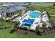 Aerial view of a community pool featuring ample lounge chairs, shaded seating, and manicured landscaping at 316 Vistera Blvd, Nokomis, FL 34275