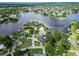 Expansive aerial view of waterfront homes nestled around a serene lake, showcasing community and lush landscapes at 3724 Fawn Grove Ct, Land O Lakes, FL 34639