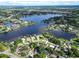 Wide aerial perspective of a community on multiple lakes and lush greenery at 3724 Fawn Grove Ct, Land O Lakes, FL 34639