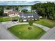 Aerial shot showcases a home with lush yard, circular driveway, and serene lake backdrop at 3724 Fawn Grove Ct, Land O Lakes, FL 34639