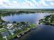 Wide angle shot of a lake with houses situated along the shoreline with plentiful trees at 3724 Fawn Grove Ct, Land O Lakes, FL 34639