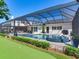 The screened-in pool and spa are adjacent to a putting green in the backyard at 3724 Fawn Grove Ct, Land O Lakes, FL 34639