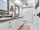 Well-lit bathroom offers a double sink vanity, framed mirrors, and white tile floors at 3724 Fawn Grove Ct, Land O Lakes, FL 34639
