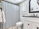 Well-lit bathroom featuring a shower with striped curtain and black hardware, offering a clean and sleek design at 3724 Fawn Grove Ct, Land O Lakes, FL 34639