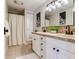 Bathroom featuring double sinks, decorative wallpaper, and a shower with a white curtain at 3724 Fawn Grove Ct, Land O Lakes, FL 34639