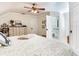 Well-lit bedroom with a neutral palette, featuring built-in storage beneath the bed, a ceiling fan and doorway to bath at 3724 Fawn Grove Ct, Land O Lakes, FL 34639