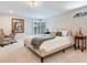 Bright bedroom featuring a large window, neutral walls, and a cozy chair at 3724 Fawn Grove Ct, Land O Lakes, FL 34639