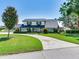 Inviting two-story home with black shutters and beautiful landscaping around the curved driveway at 3724 Fawn Grove Ct, Land O Lakes, FL 34639