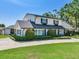 Charming two-story home with manicured landscaping, black shutters, and a long concrete driveway at 3724 Fawn Grove Ct, Land O Lakes, FL 34639
