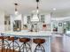 Kitchen island boasts modern pendant lighting, sleek countertops, and seating for four in the open floor plan at 3724 Fawn Grove Ct, Land O Lakes, FL 34639