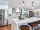 Bright kitchen with stainless steel refrigerator, custom cabinetry, island seating and a view of the back yard at 3724 Fawn Grove Ct, Land O Lakes, FL 34639
