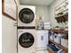 Laundry room with stacked washer and dryer, and shelving unit for storage at 3724 Fawn Grove Ct, Land O Lakes, FL 34639