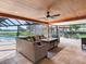 Covered patio featuring comfortable seating, a ceiling fan, and views of the pool and waterfront at 3724 Fawn Grove Ct, Land O Lakes, FL 34639