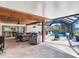 A covered patio features travertine tile, a wood ceiling, and wicker furniture around a screened-in pool at 3724 Fawn Grove Ct, Land O Lakes, FL 34639