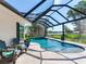 The screened-in pool has a water feature, dark metal screening, and a view of the lake at 3724 Fawn Grove Ct, Land O Lakes, FL 34639