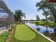 A backyard putting green is alongside a canal with a view of the lake at 3724 Fawn Grove Ct, Land O Lakes, FL 34639