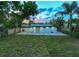 A view of the home's backyard featuring a brick patio, lush lawn and well-maintained landscaping at 3947 Overlook Ne Dr, St Petersburg, FL 33703