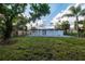 Large backyard featuring a well-manicured lawn, privacy fence, and a modern white house with patio at 3947 Overlook Ne Dr, St Petersburg, FL 33703