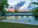 A view of the home's backyard featuring a brick patio, lush lawn and well-maintained landscaping at 3947 Overlook Ne Dr, St Petersburg, FL 33703