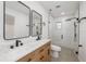 Modern bathroom featuring double sinks, sleek black fixtures, and a stylish walk-in shower with subway tile at 3947 Overlook Ne Dr, St Petersburg, FL 33703