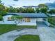 Charming single-story home featuring a metal roof, white exterior, and well-maintained front yard at 3947 Overlook Ne Dr, St Petersburg, FL 33703