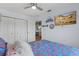 Bright bedroom features a ceiling fan, a mounted TV, and a patterned bedspread at 4137 Des Prez Ct, Hernando Beach, FL 34607