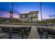 Charming waterfront home with multiple balconies, accessed by a wooden dock, surrounded by lush landscaping and clear water at 4137 Des Prez Ct, Hernando Beach, FL 34607