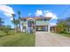 Inviting two-story home with a covered front porch, set amidst a lush green lawn, mature trees, and a paved driveway at 4137 Des Prez Ct, Hernando Beach, FL 34607