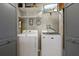 Bright laundry room with washer, dryer, shelving, and ample storage space at 4137 Des Prez Ct, Hernando Beach, FL 34607