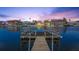 Picturesque waterfront view of the canal and neighborhood from the end of a private wooden dock at twilight at 4137 Des Prez Ct, Hernando Beach, FL 34607