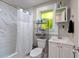 Cozy bathroom with a tub and shower, white vanity, and bright window at 4218 E Cayuga St, Tampa, FL 33610