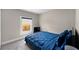 Comfortable bedroom featuring a cozy bed with blue covers and a bright window at 4218 E Cayuga St, Tampa, FL 33610