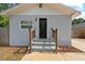 Charming home entrance with a black front door, complemented by elegant wooden handrails and well-manicured landscaping at 4218 E Cayuga St, Tampa, FL 33610