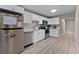 Modern kitchen featuring stainless steel appliances, white cabinets, and light wood flooring at 4218 E Cayuga St, Tampa, FL 33610
