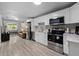 Open-concept kitchen and living area with stainless steel appliances and comfortable leather seating at 4218 E Cayuga St, Tampa, FL 33610