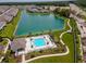Aerial view of community pool, clubhouse, and lake surrounded by beautiful landscaping at 4262 Cloud Hopper Way, Lutz, FL 33559